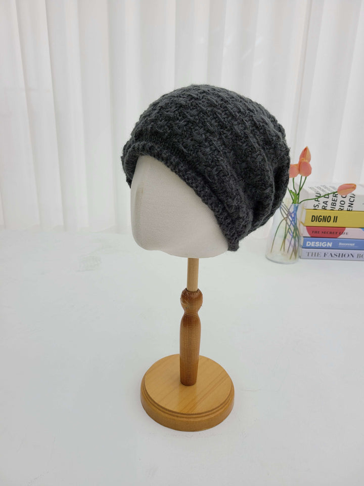 Gray knit beanie on a mannequin head with a wooden stand against a white background