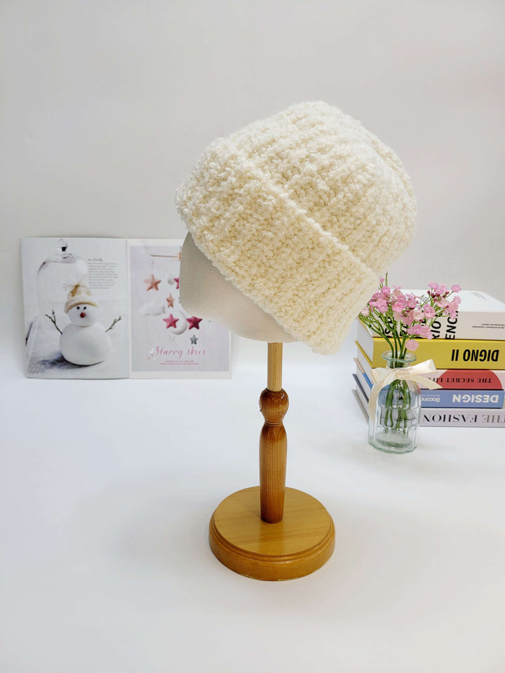 White textured beanie on a wooden mannequin head with a white background