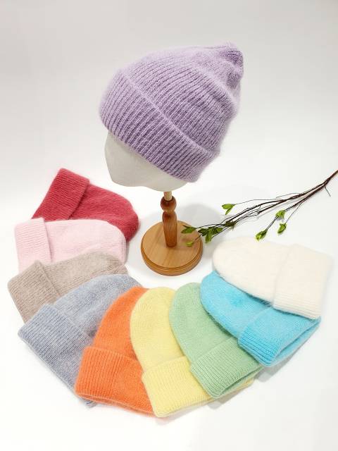Collection of colorful knit hats on a mannequin and white background