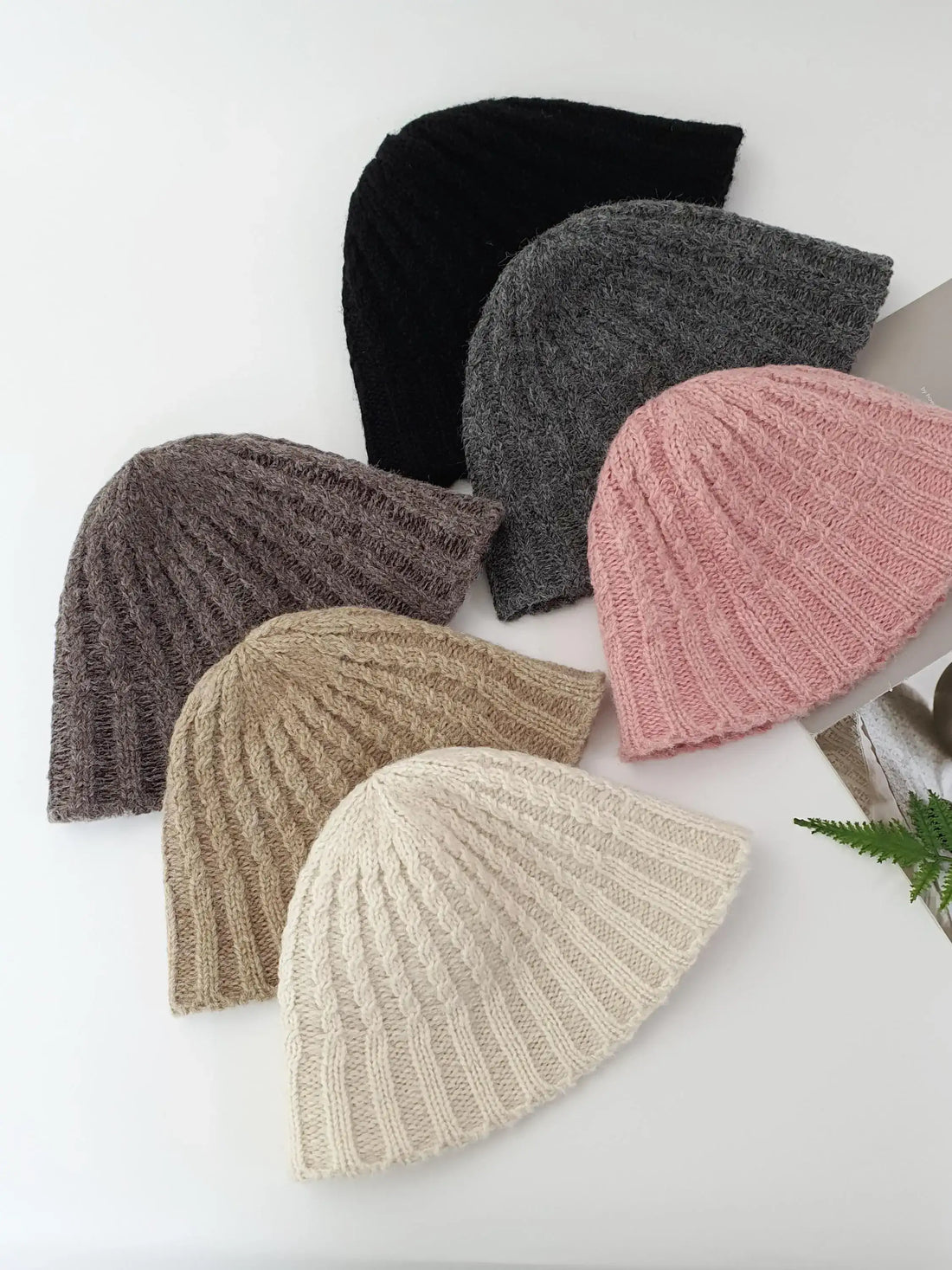 Six knitted beanies the wool-vol3 in black, gray, brown, beige, tan, and pink. Ribbed texture, soft wool blend, stylish and warm headwear.
