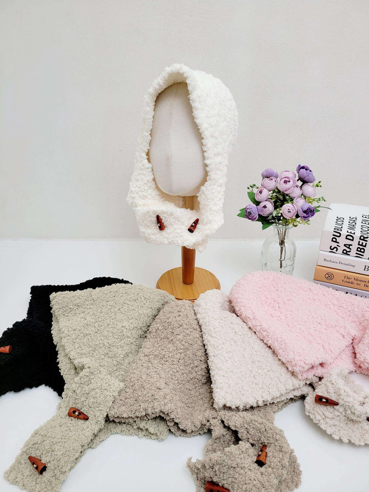 White fluffy balaclava on a mannequin, with black, beige, tan, and pink fluffy balaclavas displayed below. Cozy and stylish headwear.