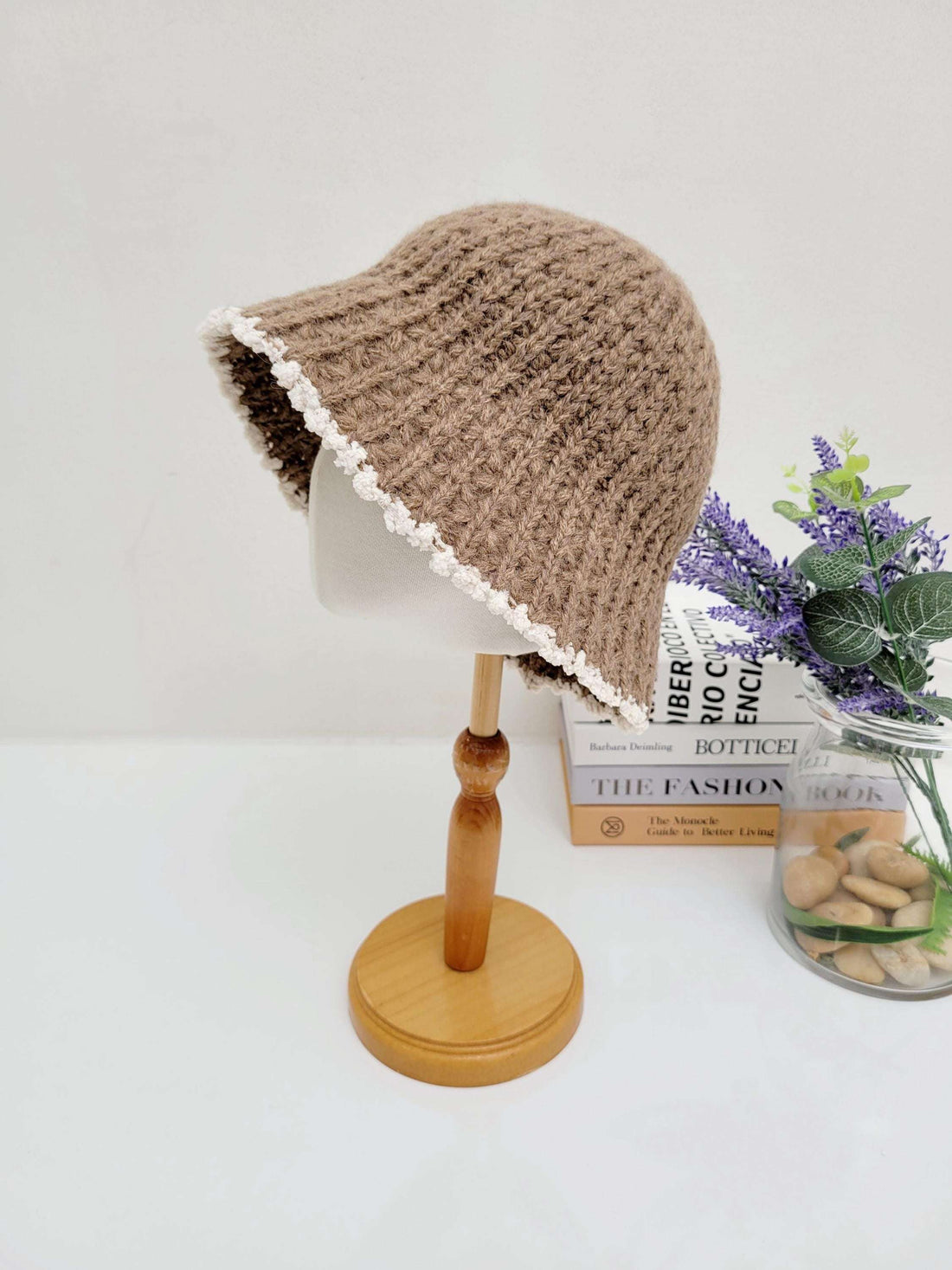 Brown vintage knitted beanie with a delicate white scalloped brim, displayed on a mannequin head.