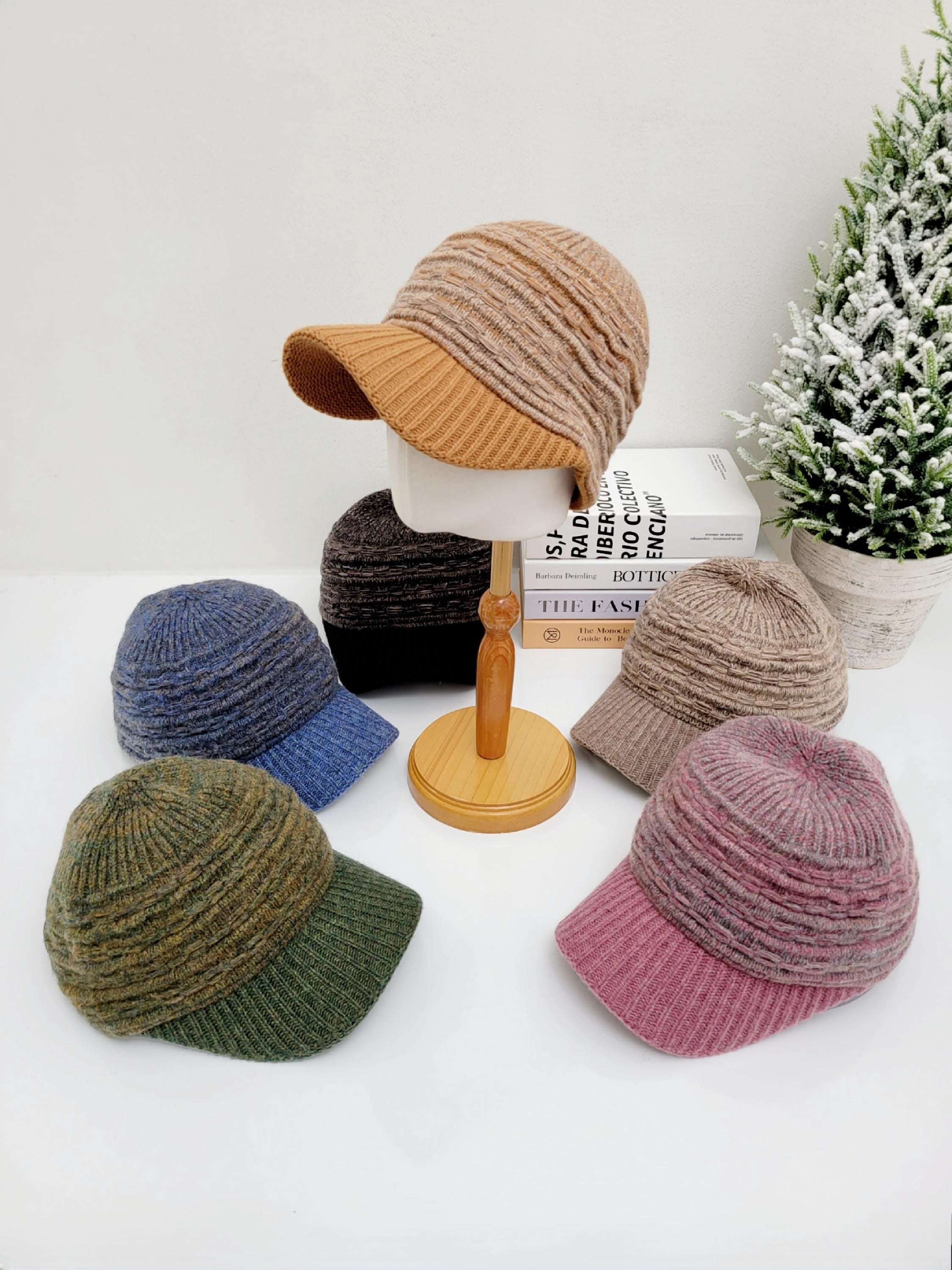 Assorted clara winter cap collection: knit caps with brims in brown, blue, green, pink & black on a white surface