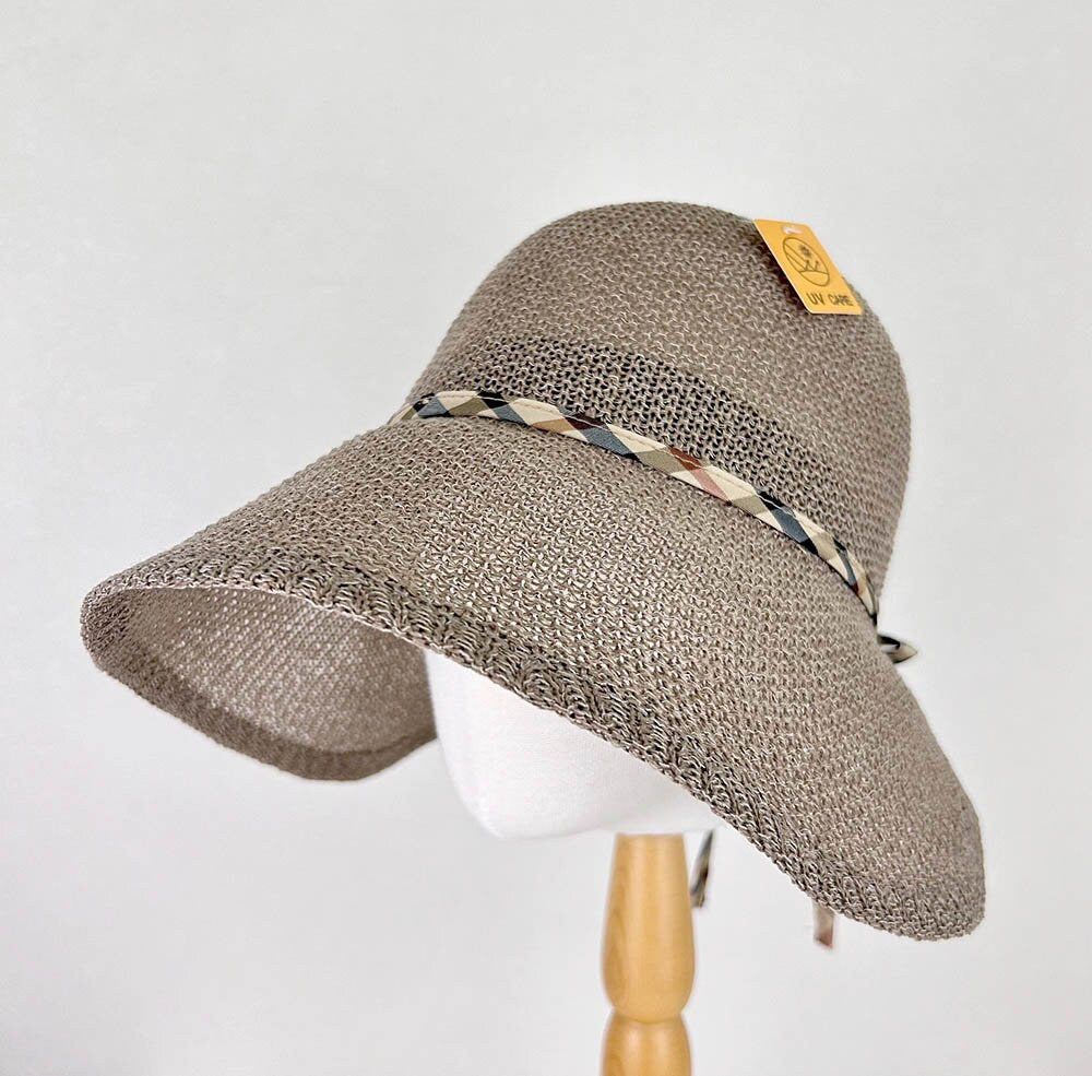 Brown woven sun hat with wide brim and patterned ribbon accent, ideal for sun protection and stylish outdoor wear. Kelly's picnic hat.
