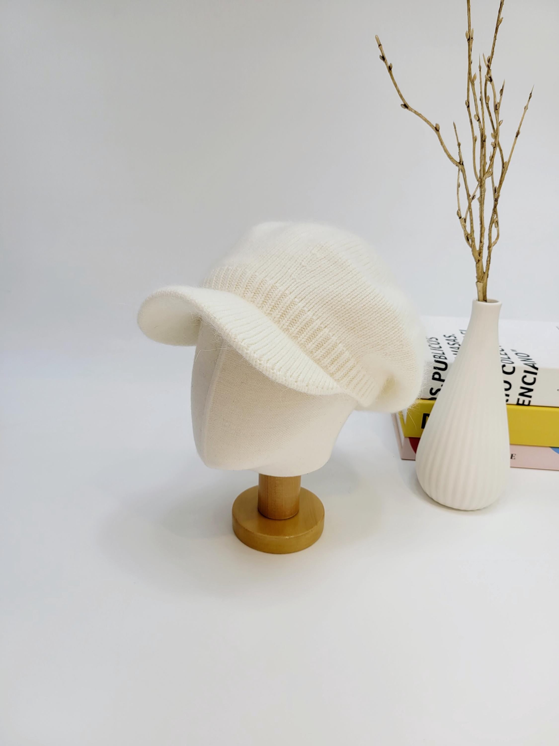 White knitted angelina in love beret hat displayed on a mannequin head. Classic and stylish accessory.